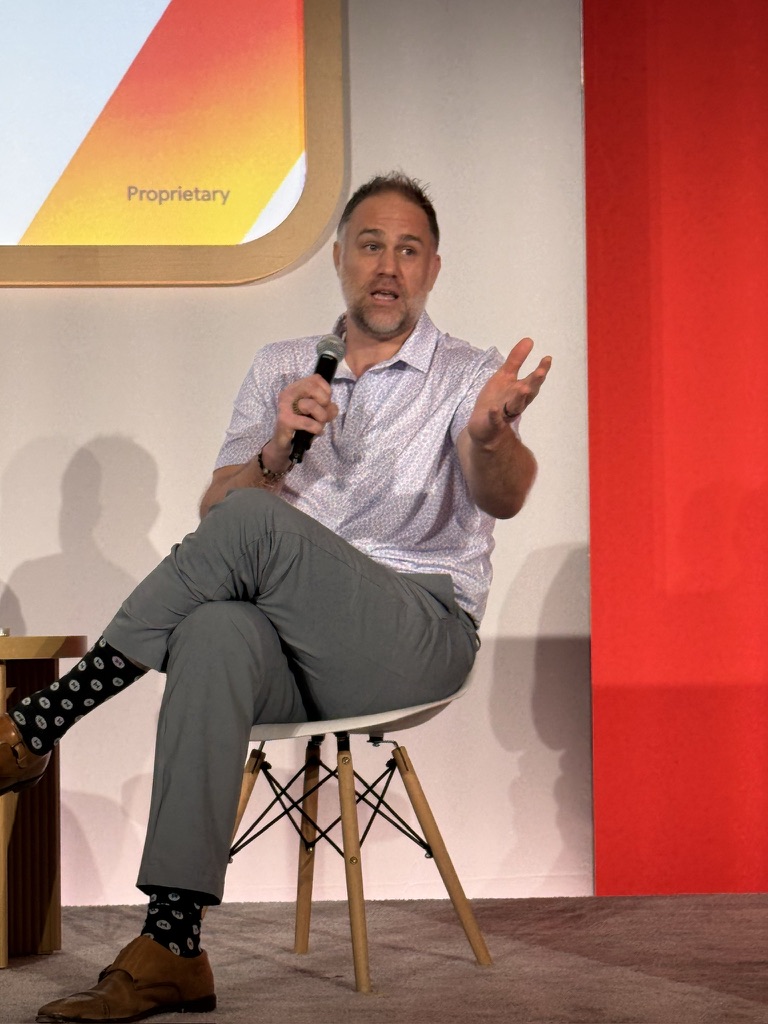 John Wingate speaking on stage at Google Next